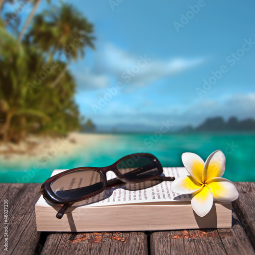 Photo: Lunettes de soleil et livre fond plage exotique Lunettes de soleil et livre fond plage exotique