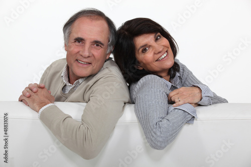Photo: Adult couple stood with blank advertising panel Adult couple stood with blank advertising panel