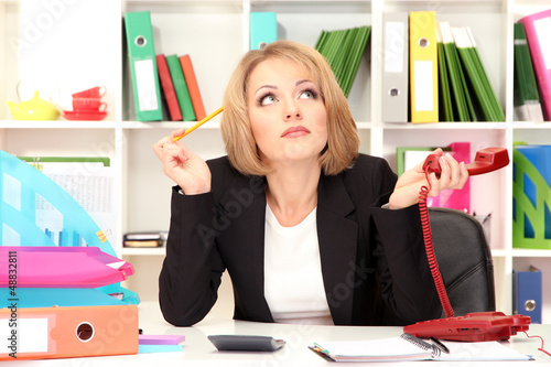 Photo: Beautiful young business woman working in office Beautiful young business woman working in office