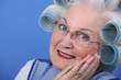 Elderly lady using hair rollers
