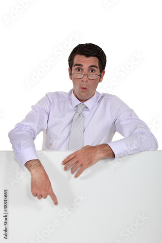 Photo: executive looking amazed pointing at copyspace executive looking amazed pointing at copyspace