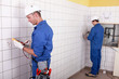 Workteam installing electrics in a tiled room