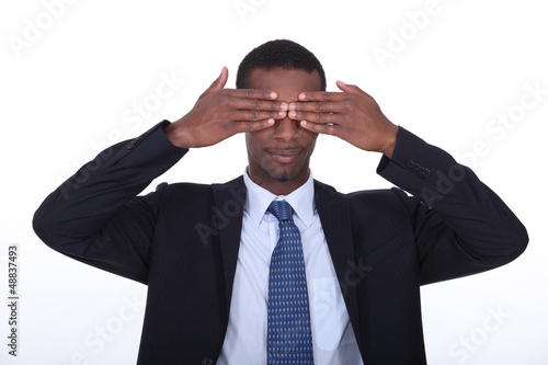 Photo: Black man covering his eyes Black man covering his eyes