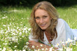Woman lying in a field of daisies