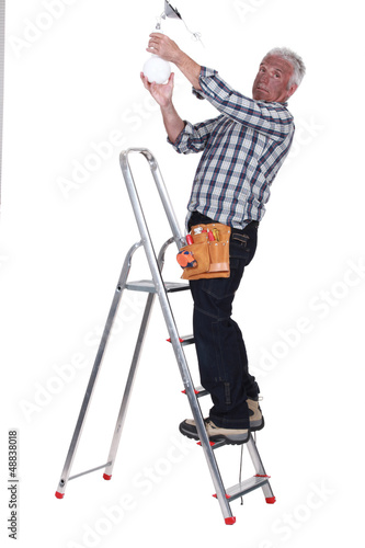 Photo: electrician fixing a bulb electrician fixing a bulb