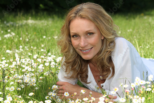 Photo: Woman lying in a field of daisies Woman lying in a field of daisies