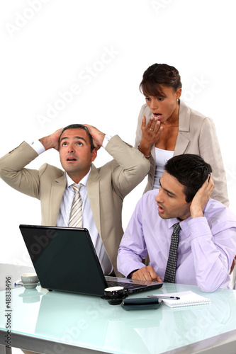 Photo: Three shocked business people looking at results Three shocked business people looking at results