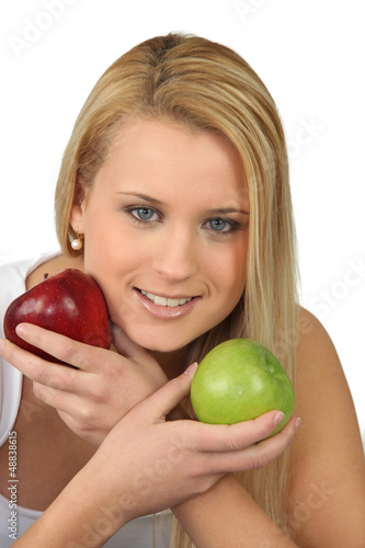 Photo: Blond woman choosing between red and green apples Blond woman choosing between red and green apples