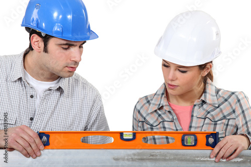 Photo: female apprentice and carpenter using ruler female apprentice and carpenter using ruler