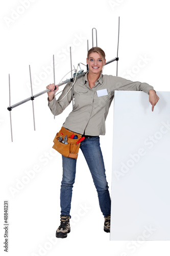 Photo: Woman holding TV antenna with white sign Woman holding TV antenna with white sign