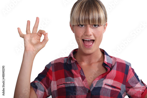 Photo: Cheerful blond woman giving the OK Cheerful blond woman giving the OK