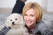 Woman lying on rug with poodle