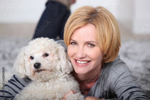 Photo: Woman lying on rug with poodle Woman lying on rug with poodle