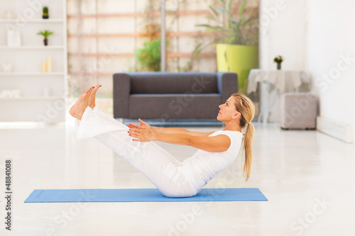 Photo: mid age woman doing yoga exercise at home mid age woman doing yoga exercise at home