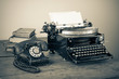 Vintage phone, old typewriter, books on table desaturated photo