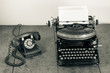 Vintage telephone, old typewriter on wooden table