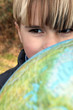 Little boy stood outdoors with globe