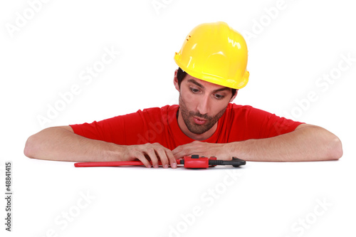 Photo: Plumber looking at his tool surprisingly Plumber looking at his tool surprisingly