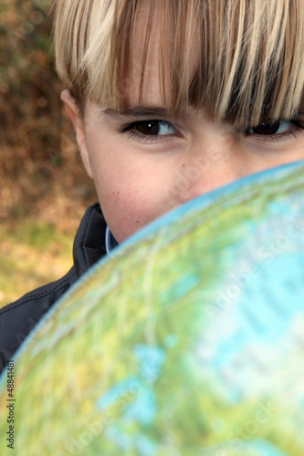Photo: Little boy stood outdoors with globe Little boy stood outdoors with globe