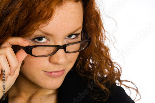 Photo: Flirting woman looking over her glasses Flirting woman looking over her glasses