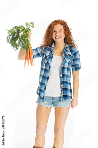 Photo: Beautiful woman with garden fresh carrots Beautiful woman with garden fresh carrots