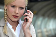 Businesswoman on the phone at a train station