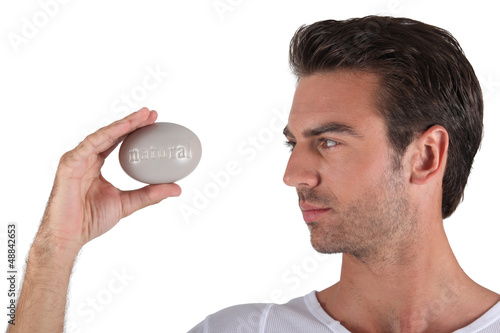 Photo: Man holding pebble in hand Man holding pebble in hand
