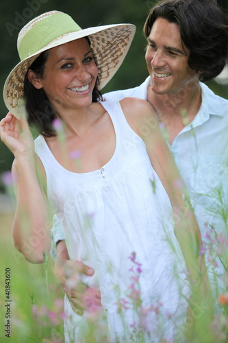 Photo: Couple relaxing in field Couple relaxing in field