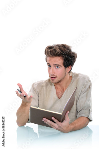 Photo: Man writing in a journal Man writing in a journal