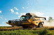 Yellov combine on field harvesting gold wheat
