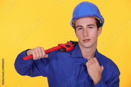Photo: Young worker with wrench in the shoulder Young worker with wrench in the shoulder