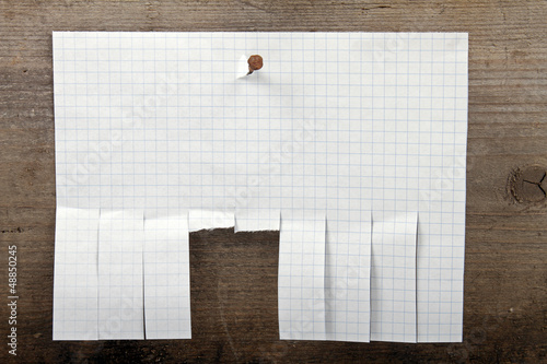 Photo: advertisement paper with cut slips hanging on nail advertisement paper with cut slips hanging on nail