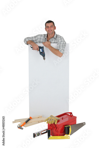 Photo: Handyman posing with a blank sign and his tools Handyman posing with a blank sign and his tools