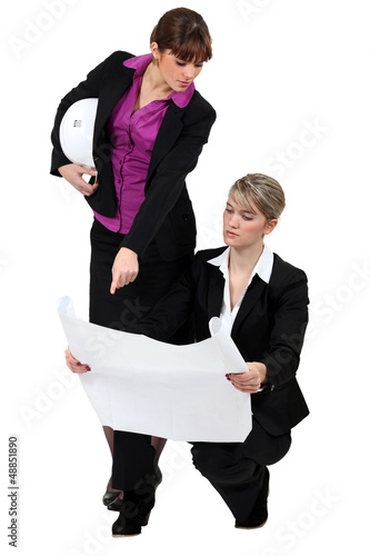 Photo: two businesswomen looking at a blueprint two businesswomen looking at a blueprint