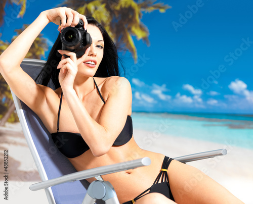 Photo: woman with a camera taking photos on beach woman with a camera taking photos on beach