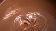 Almonds falling into melted chocolate
