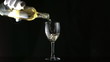 Gloved hand pouring white wine into glass in slow motion