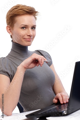 Photo: Smiling businesswoman working on laptop Smiling businesswoman working on laptop