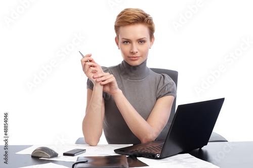 Photo: Beautiful businesswoman sitting at desk Beautiful businesswoman sitting at desk