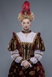 Haughty queen in royal dress isolated on grey