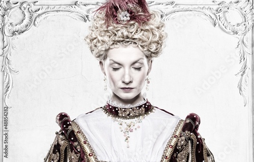 Photo: Her royal highness standing against wall with stucco works Her royal highness standing against wall with stucco works