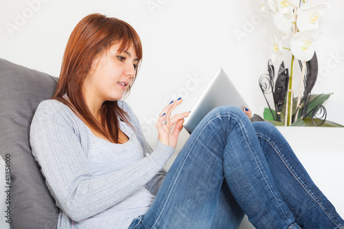 Photo: Beautiful Young Woman with Tablet PC on the Sofa Beautiful Young Woman with Tablet PC on the Sofa