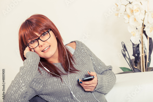 Photo: Beautiful Young Woman Listening Music on the Sofa Beautiful Young Woman Listening Music on the Sofa