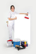 Painter posing with her supplies next to a blank sign