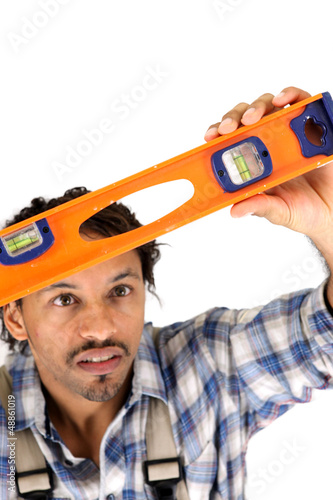 Photo: Worker carefully watching his level spirit Worker carefully watching his level spirit