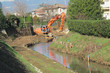 bulldozer at work on the bed of a river during consolidation of