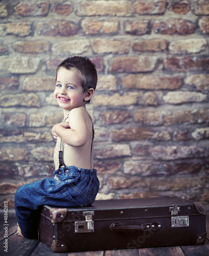 Photo: Small kid playing on the suitcase Small kid playing on the suitcase