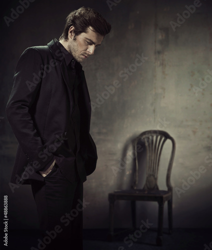 Photo: Handsome man in a business suit on a dark background Handsome man in a business suit on a dark background