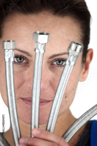 Photo: Female plumber holding replacement parts Female plumber holding replacement parts