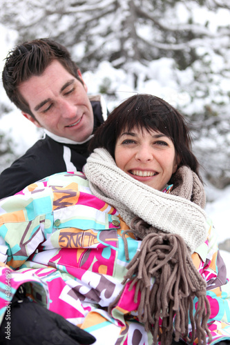 Photo: Flirtatious couple playing in the snow Flirtatious couple playing in the snow